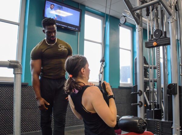 A man and woman in the gym doing exercises.